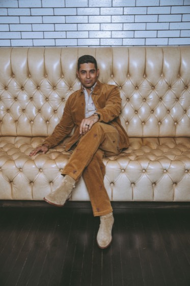 Personal brand portrait, tan suit on a cream tufted sofa