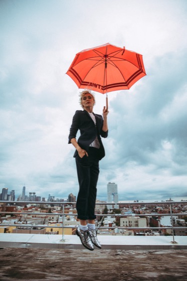 Editorial personal brand portrait with a red umbrella on a rooftop